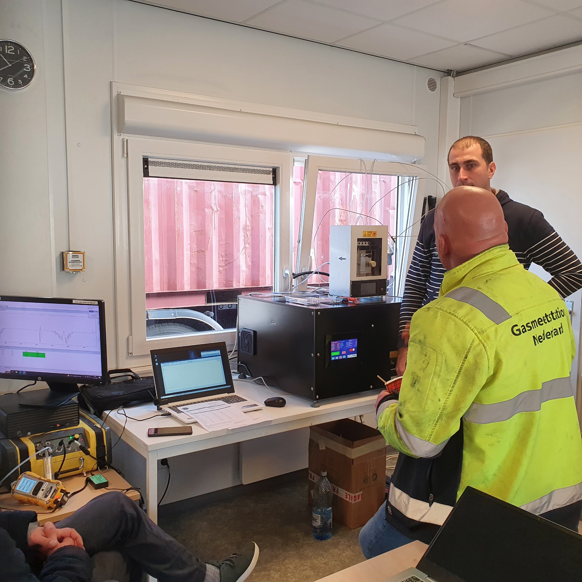 Labio engineer and a Gasmeetstation Nederland surveyor analysing a sample from a sealed shipping container at the Port of Rotterdam, with the INSCAN GC-UV system on the bench